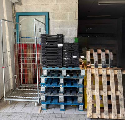de nombreuses palettes de bois empilées les unes sur les autres dans un entrepôt