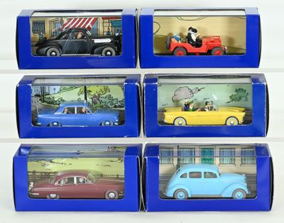 six toy cars are in a blue box on a white surface