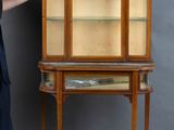 a woman that is standing next to a cabinet