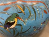 a blue vase with a bird painted on it