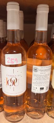 plusieurs bouteilles de vin sont alignées sur une étagère dans un magasin