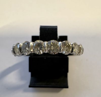un gros plan d'une bague en diamant posée sur un socle noir