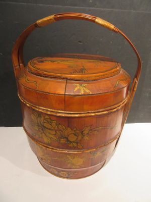a small wooden basket with a handle on a table