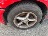 the tire of a red car with a flat tire on the road