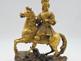 figurine en bronze représentant un homme à cheval sur un rocher