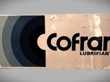 une vieille enseigne sur laquelle est inscrit « Cofran Lubrifiants »