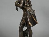 bronze statue of a boy with a bird on a pedestal