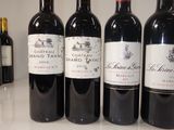 several bottles of red wine are lined up on a counter