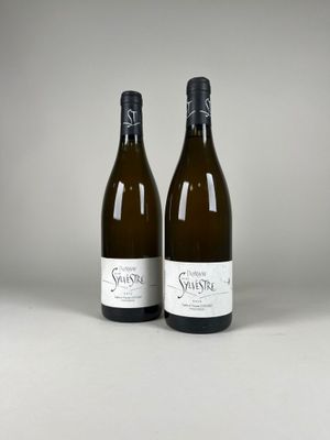two bottles of white wine sitting next to each other on a table