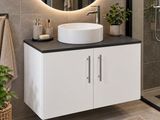 un lavabo blanc placé sous un miroir rond dans une salle de bains