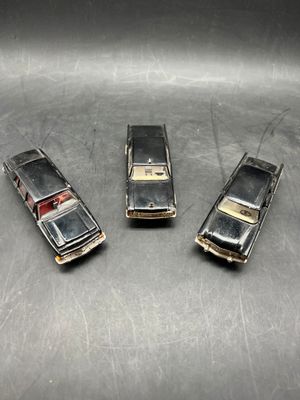 three old model cars that are sitting on a table