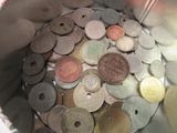 une personne tenant un récipient métallique rempli de pièces de monnaie