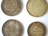 quatre types de pièces différents posés sur une surface blanche
