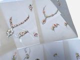 many different types of jewelry on display in a box