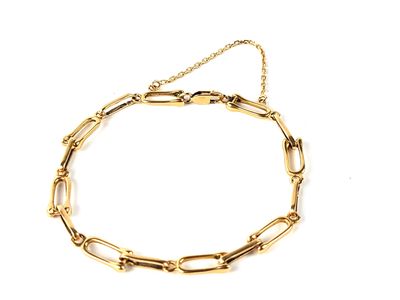 gros plan d'un bracelet en chaîne en or sur fond blanc