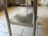 a stainless steel table in the middle of a kitchen