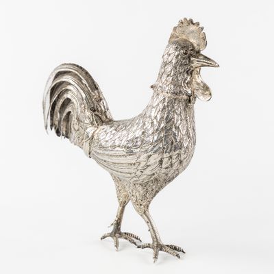 Un grand coq en argent avec les plumes de la queue ajourées,…