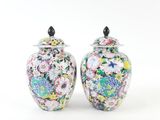 pair of colorful vases sitting on a white surface with a white background