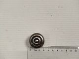 a small metal object on a ruler next to a ruler