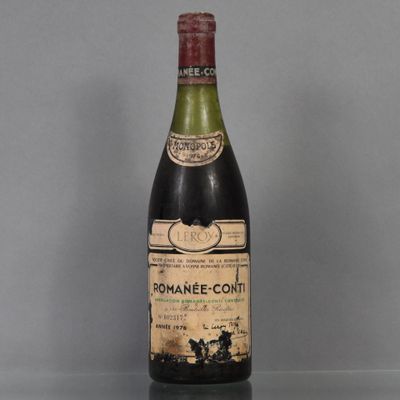 une vieille bouteille de vin posée sur une table en verre