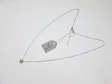 un collier auquel est attachée une étiquette sur une surface blanche
