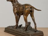 bronze statue of a dog on a wooden base on a table