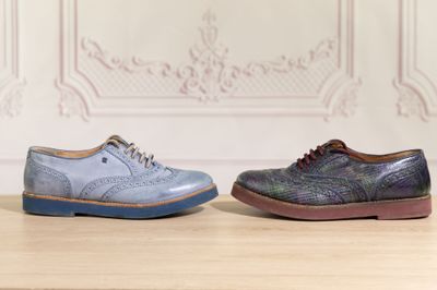 pair of blue and purple shoes sitting on top of a wooden table