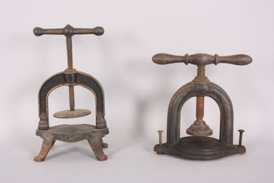 two old fashioned ironing tools sitting side by side