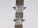 an image of a metal object hanging on a white wall