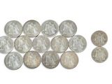 some silver coins are arranged in a row on a white surface