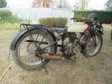 a old motorcycle that is parked in the grass