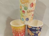 three cups with different designs on them sitting on a table