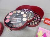 a red box with a lipstick, eye shadow, and other makeup items