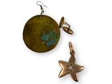 deux boucles d'oreilles et une étoile sont posées sur une surface blanche