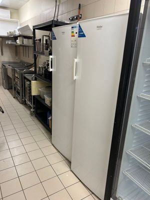 un réfrigérateur blanc dans une cuisine, à côté d'un plan de travail