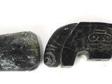 two pieces of black stone on a white surface