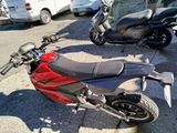 a red and black motorcycle parked on the side of the street