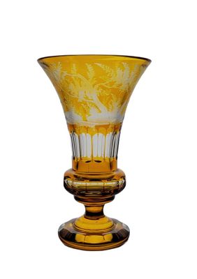 a yellow glass vase with a floral design on it