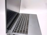 a silver laptop with a black keyboard on a white surface