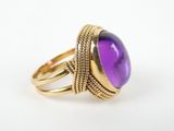 a gold ring with a purple stone on top of it