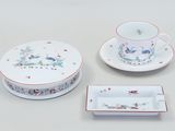 three pieces of porcelain dishes and a cup and saucer on a table
