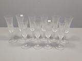 six verres à vin transparents sont alignés sur une table blanche