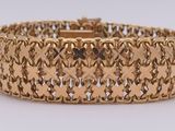 gros plan d'un bracelet en or sur une surface blanche