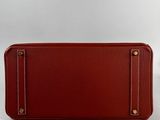 a red leather wallet with gold hardware on the front