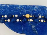 un gros plan d'une broche bleue ornée de perles