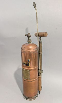 un extincteur en cuivre à l'ancienne muni d'un tuyau