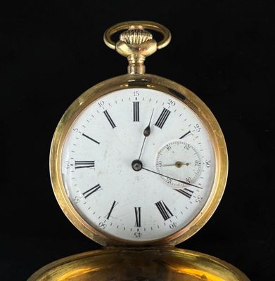 a gold pocket watch with roman numerals on the face