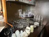 a bar with a lot of glasses and cups on it