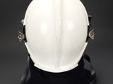 a white hard hat on a black base on a black background