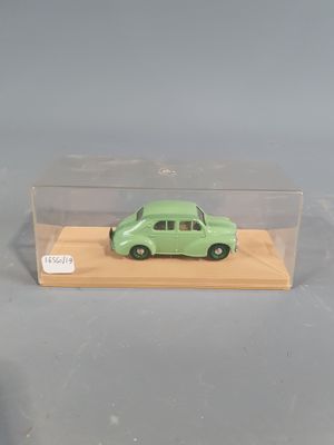 a green toy car in a clear box on a table